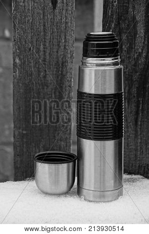 iron gray flask with a cup in the snow