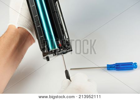 Modern service of repairing printers. Man checking printer catridge