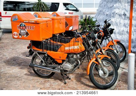 Cozumel Mexico - December 24 2015: hooters motorcycles of orange color parked on street outdoor. Food delivery service concept