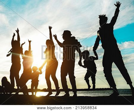 Silhouette Of Big Family Having Fun On The Beach At Sunset - Father Mother Children And Uncles Enjoy