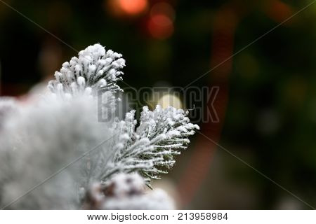 Winter holidays background of pine cones powdered with artificial snow and white downy shawl. Merry Christmas brown backdrop.