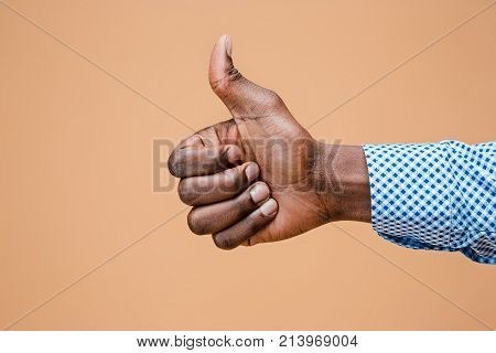 Hand showing OK sign isolated on brown background. Close-up of positive gesture, like, agreement, accept concept concept