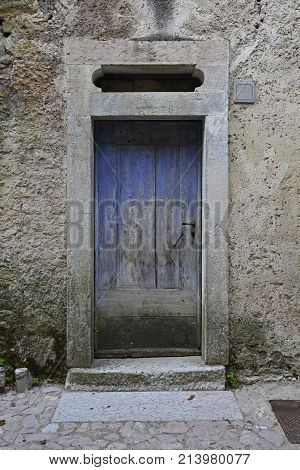 An old wooden door in a derelict building the historic hill village of Erto in Friuli Venezia Giulia north east Italy