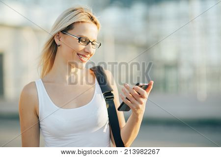 A stylish business woman reads a message on the phone