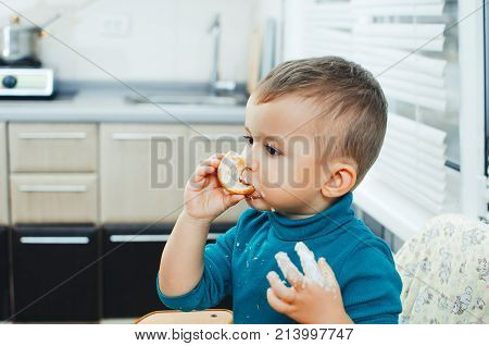 Baby In The Kitchen Eagerly Eating The Delicious Cream Horns, Vanilla Cream