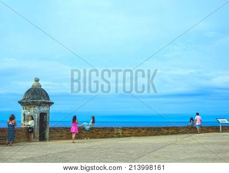 San Juan, Puerto Rico - May 08, 2016: The people making photos at large outer wall with sentry box of fort San Cristobal in San Juan, Puerto Rico on May 08, 2016