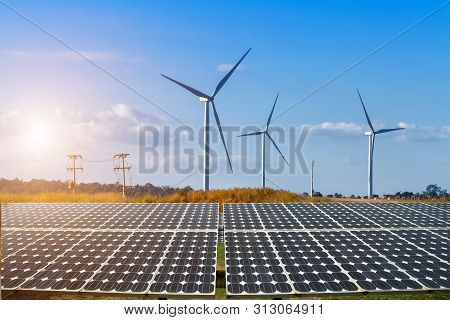 Solar Panels With Wind Turbines Against Mountanis Landscape Against Blue Sky With Clouds,alternative