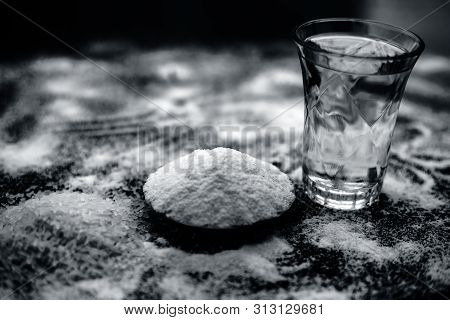Rice Water In A Glass Bowl Along With Rice Grains & Its Powder Also On Wooden Surface & Some Rice Po