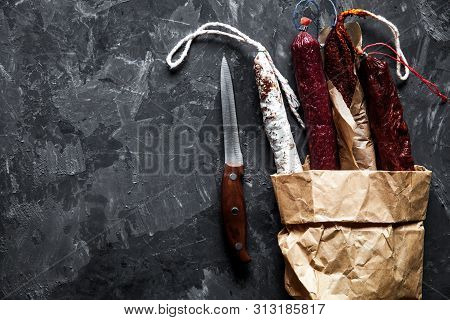 Sausages On A Paper Texture On A Dark Background With Pepper A