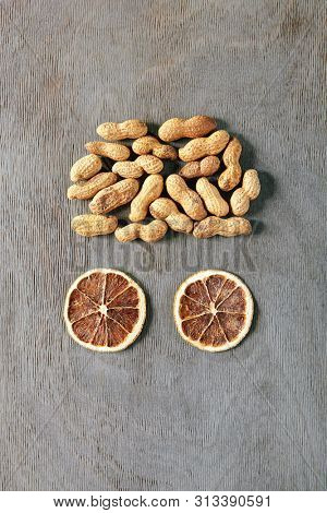 Food Art Concept with Abstract Brain made of Dried Orange Slices and Whole Peanuts Brain Top Vew. Creative Layout with Eyed Human Face