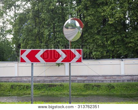 Reflection Of Road In The Traffic Safety Mirror. Road Traffic Mirrow And The Red Traffic Sign With T