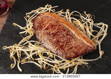 Kobe Meat, Wagyu Beef Steak, Seared, With Soy Sprouts, On A Black Plate