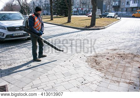Dnepropetrovsk, Ukraine - 03.16.2021: A Worker On The Street In Early Spring Removes Leaves And Dust