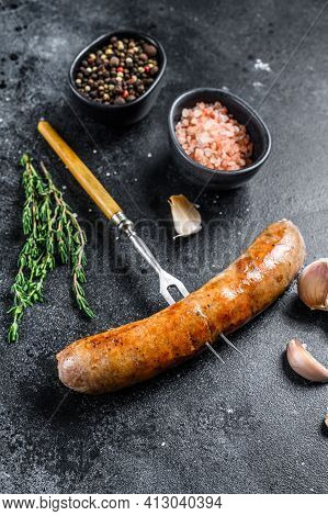 Pork Sausage Bbg Grilled With And Herbs On A Meat Fork. Top View. Black Background