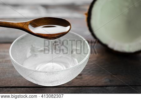 Cold Pressed Coconut Oil Wooden Spoon. Made From Nature On Wooden Background. Pure White Oil. Herb A