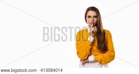 Portrait Of Young Brunette Woman Keeping Finger At Her Mouth, Saying Shh, Hush, Tsss. Silence And Se