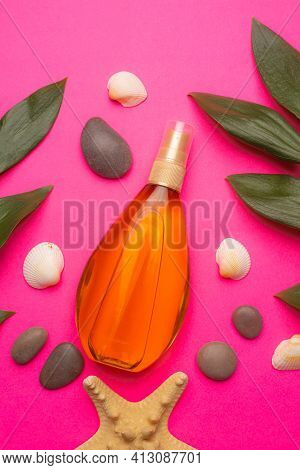 Suntan Oil On A Pink Background . Suntan Oil And Green Leaves. Vacation. Protect Your Skin From The 
