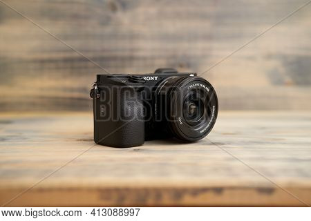 Budva, Montenegro - 15 March 2021: Sony A6300 Camera With 16-50mm Lens On Wooden Background Texture.