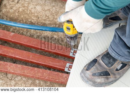 Man Assembling Composite Deck Using Cordless Screwdriver.