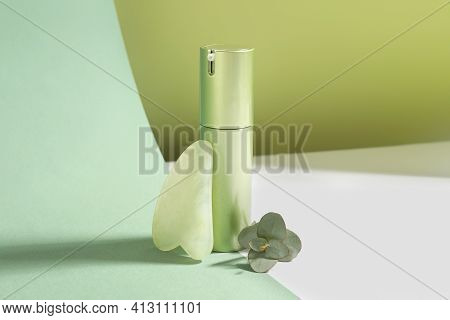 Jade Gua Sha Tool, Eucalyptus Branch And Cosmetic Product On Color Background
