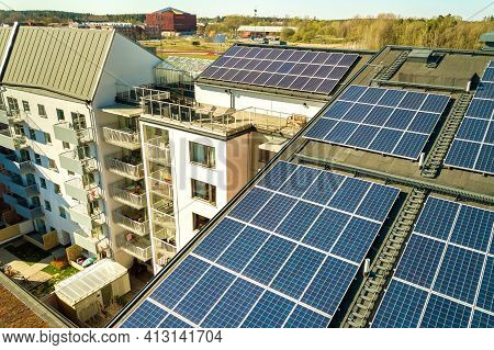 Aerial View Of Solar Photovoltaic Panels On A Roof Top Of Residential Building Block For Producing C