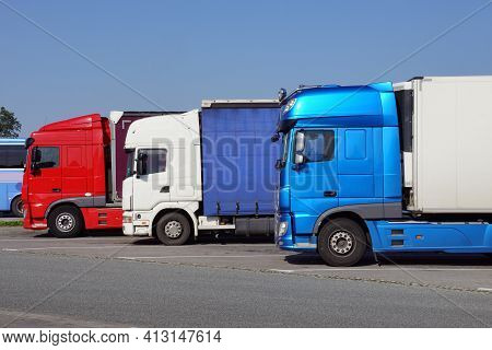 Truck Stop. Various Types And Colors Of Cabins. Trucks Parked In A Row. Break In A Trip.