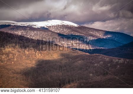 Spring Sunny Landscape Of Snowy Mountains With Stormy Sky