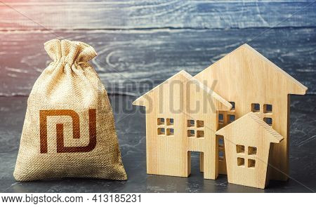 Israeli Shekel Money Bag And Figurines Of Residential Buildings. Property Tax. Financing Urban Devel