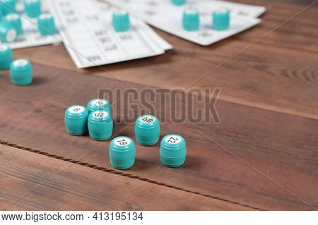 Many Barrels With Numbers And Cards For Lotto Or Russian Bingo Table Game On Wooden Surface. Russian