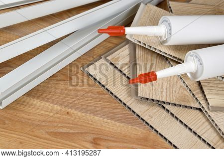 Set Of Items For Pvc Ceiling Indoor Works. Assembly Adhesive Bottles And Pvc Panels With Plastic Cor