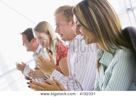 Four Businesspeople Applauding Indoors Smiling