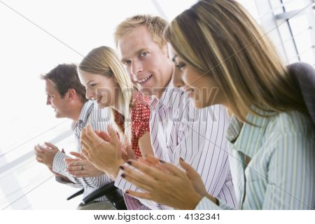 Four Businesspeople Applauding Indoors Smiling