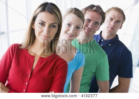 Cuatro personas de pie en el pasillo sonriendo