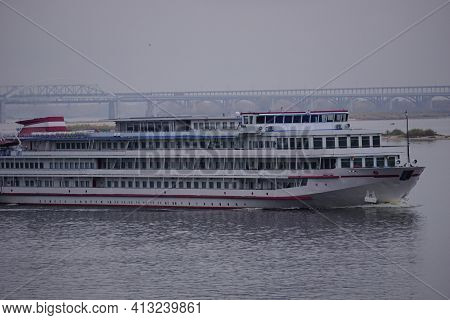 The Passenger Motor Ship Ruristic Three-deck Goes Along The River, In The Background Is A Large Brid