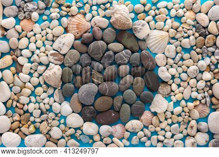 Sea Pebbles And Shells On A Blue Background