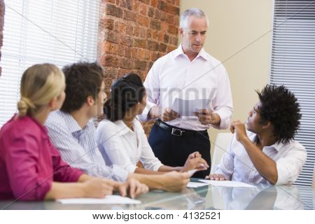 Cinco empresarios en reunión de sala de juntas