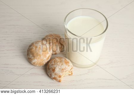 Tasty Homemade Gingerbread Cookies And Glass Of Milk On White Wooden Table