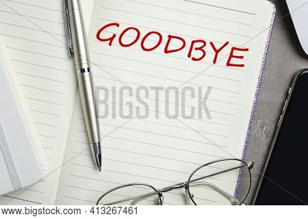 Notebook With Word Goodbye, Pen And Glasses On Table, Closeup