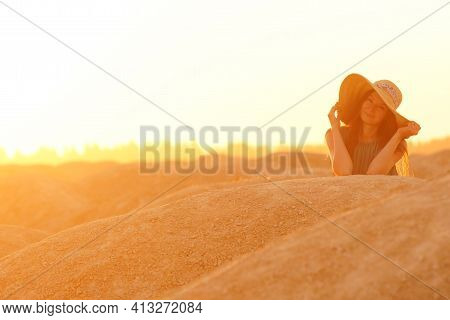 Portrait Of Young Beautiful Lonely Woman With Long Hair With Straw Hat On Head And In Blue Long Summ