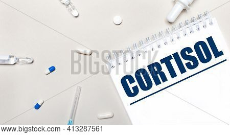 On A Light Background, A Syringe, A Stethoscope, Vials Of Medicine, An Ampoule And A White Notepad W