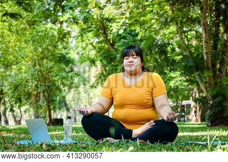 Fat Asian Women Wearing Yellow Tops Exercise In The Park. Sit In Yoga Poses, Practice Meditation, An