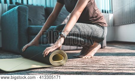 Woman hands is rolling up exercise mat and preparing to doing yoga or the end of physical activity, 