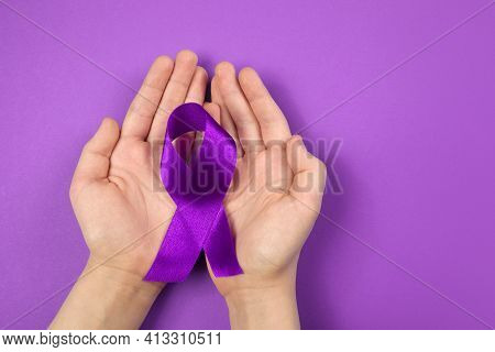 Purple Day. World Epilepsy Day. Hands Holding Purple Ribbon On Purple Background