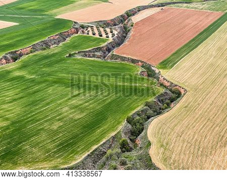 Aerial View Of Recently Planted Cereal Crops, Separated By Furrows Created By Soil Erosion, Horizont