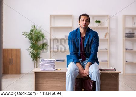 Young male employee in oversleeping concept