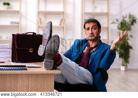 Young male employee in oversleeping concept