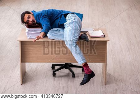 Young male employee in oversleeping concept