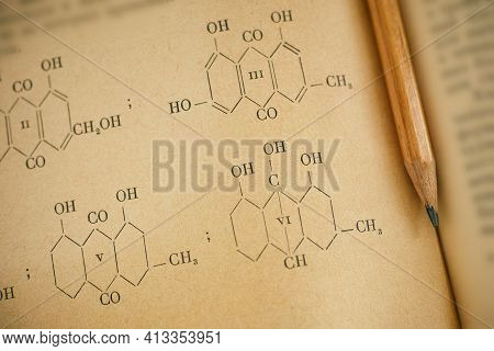 Open Page Of Old Chemistry Book With Chemical Formulas And Pencil. Close-up