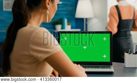 Back Shot Of Freelencer Woman Looking At Laptop With Mock Up Green Screen Chroma Key While Working A