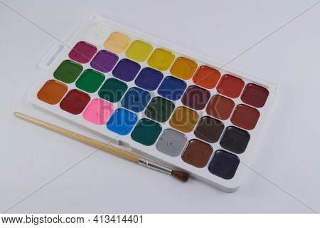 A Palette Of Welded Paint With A Brush Lying Next To It For Painting. Artistic Concept. Drawing Tool